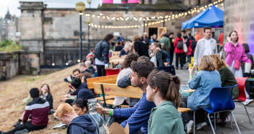 Festival goers sitting outside Royal High School